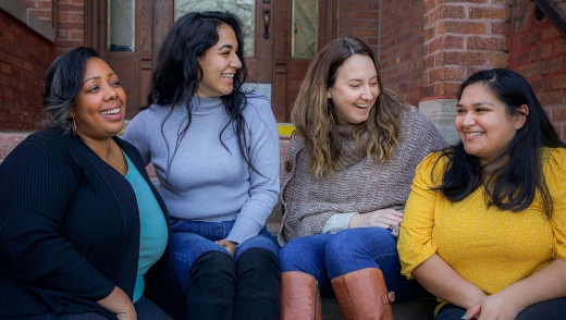 Four people sitting and smiling at each other